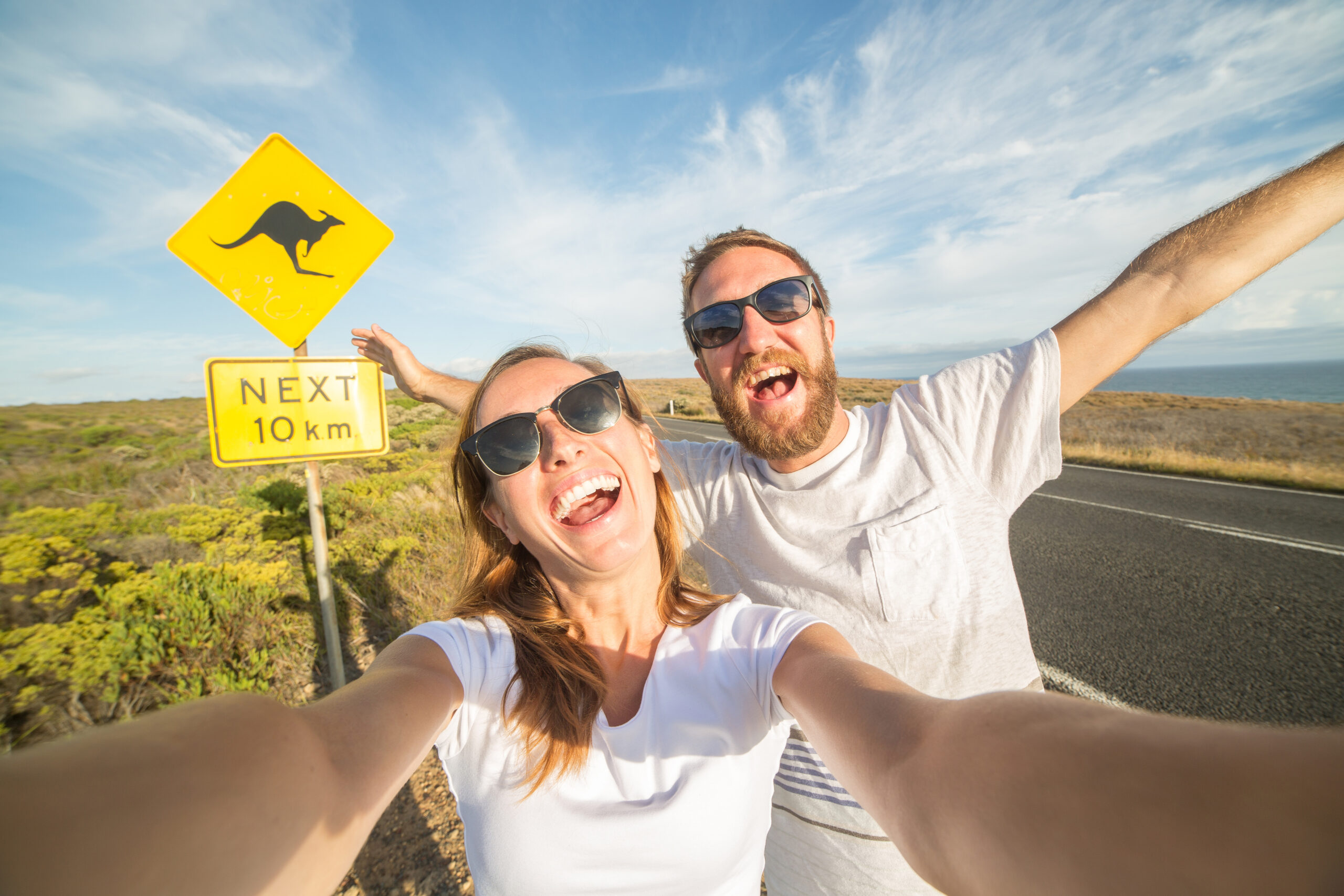 Young couple take selfie portrait near kangaroo warning sign-Australia